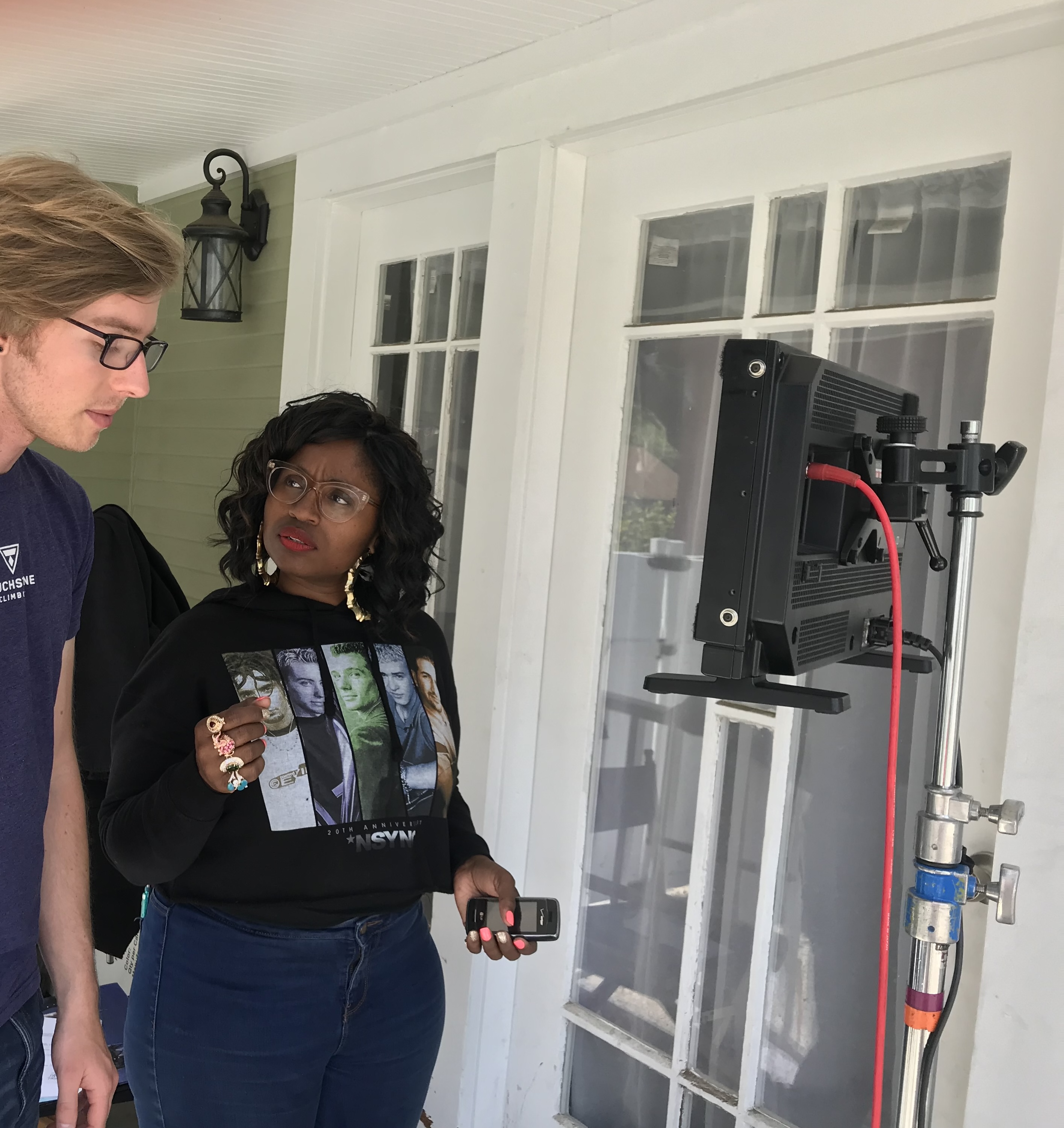 Eliyannah, director, on set standing in front of a monitor talking to a crew member